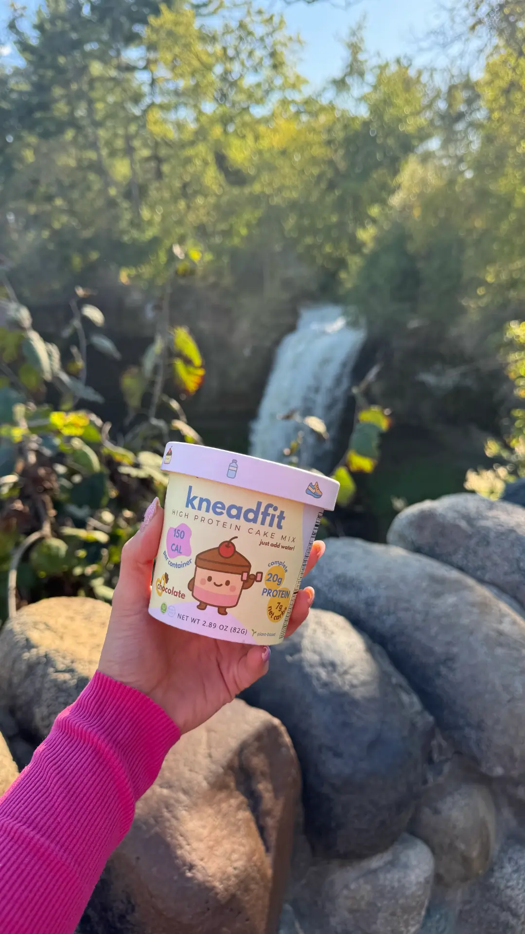 Holding a KneadFit chocolate cup in front of a waterfall